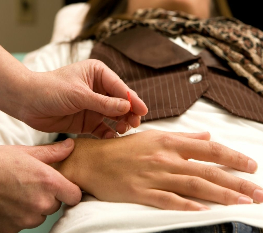 Livonia acupuncturist sticking needle into patient's hand joint